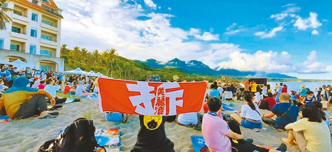 台东县府与卑南乡公所21日邀请优人神鼓演出，为杉原海水浴场重新开放暖身。有民眾到场高举「拆」字，认为杉原湾旁的美丽湾建物应拆除。（民眾提供／蔡旻妤台东传真）