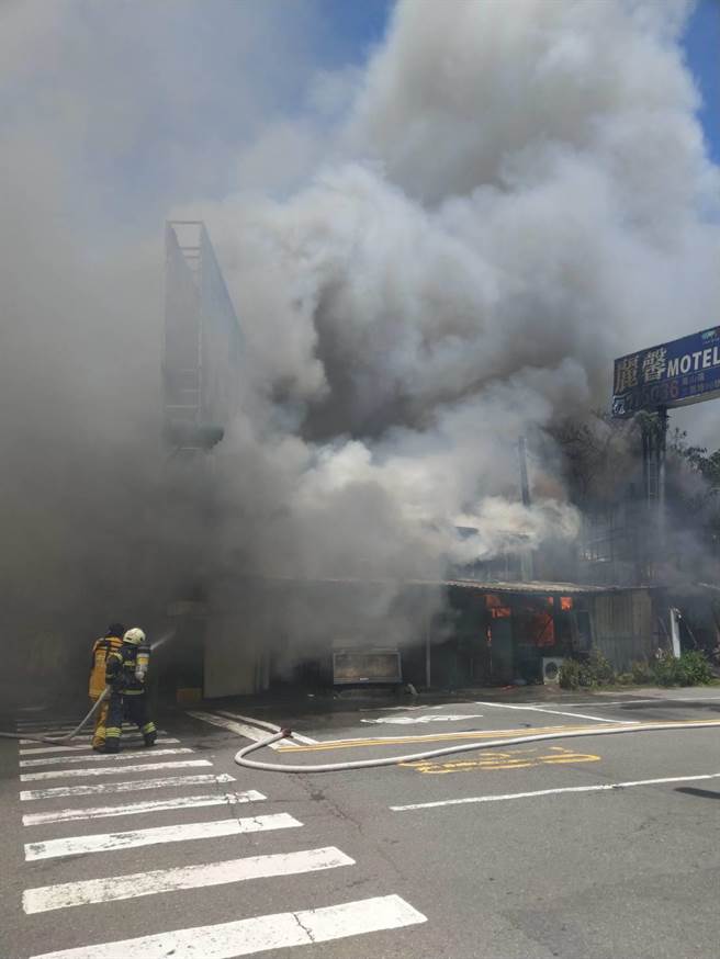 高雄市本館路一家 23日中午突傳火警，濃煙瞬間吞沒燃燒建物，消防員冒險射水搶救。（翻攝照片／石秀華高雄傳真）