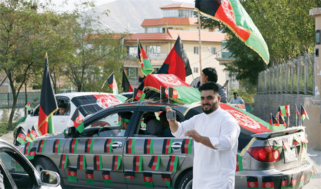 雖然阿富汗政府軍慘敗，但阿富汗人的愛國心卻起來了，阿富汗人以三色舊國旗做為反抗象徵。(圖/美聯社)
