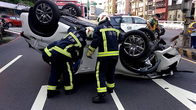 基隆市仁愛區南榮路、南新街口今早6點多有一台白色休旅車自撞分隔島，翻覆於路中央。（基隆市消防局提供／陳彩玲基隆傳真）