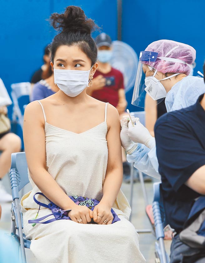 高端疫苗23日開打，台北長庚疫苗注射站一早就有不少年輕人前往接種，露出緊張表情。（陳俊吉攝）