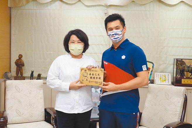 嘉义市长黄敏惠（左）致赠桧木雷雕，嘉许王翌达是嘉义之光、台湾之光。（嘉义市政府提供／廖素慧嘉市传真）