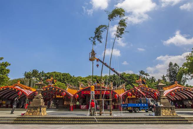 新竹县新埔镇褒忠亭义民庙祭典「竖灯篙」，用吊车协同人力作业，花了约半小时矗好3根灯篙。（罗浚滨摄）