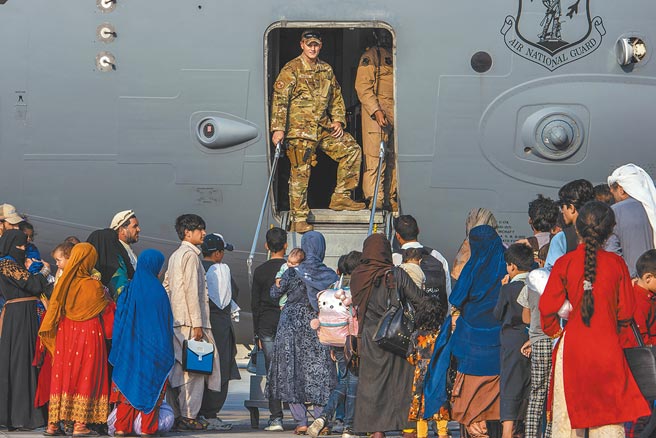美國正加快速度，自阿富汗撤出美國公民和想要外逃的阿富汗人。在卡達的烏代德空軍基地，一群阿富汗人正準備登上一架C-17空中霸王運輸機，前往其他地點接受安置。（摘自美國國防部官網）