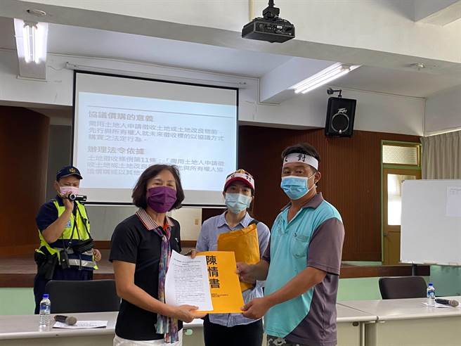 嘉义县鹿草乡公所26日上午针对都计道路4－1暨3－6道路拓宽工程进行协议价构会议，3－6地主之一叶英俊（右）等人到公所前抗议，并递交陈情书给乡长杨秀玉（左）。（张亦惠摄）