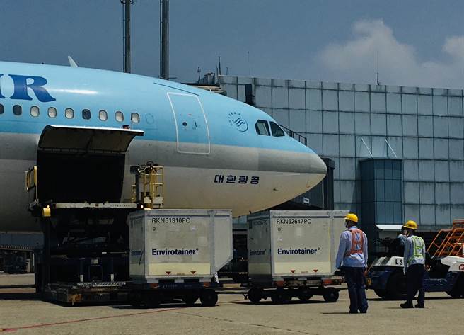 台湾自购的AZ疫苗中午运抵桃园机场，地勤人员把两个装有疫苗的货柜卸下。（范扬光摄）