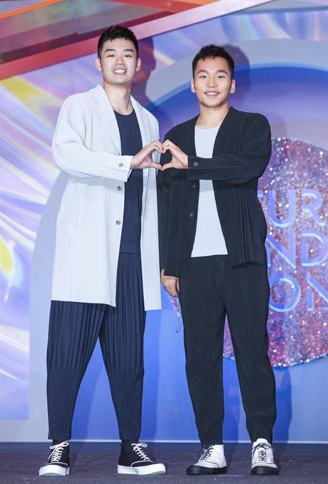 「麟洋配」穿HOMME PLISSE ISSEY MIYAKE男装展现帅气，王齐麟（左）穿浅灰色基本款长版西装外套2万3300元、海军蓝基本款圆领短袖上衣5800元、海军蓝基本款压褶长裤1万800元；李洋（右）穿黑色剪裁绉褶无领西装外套2万1300元、浅灰色基本款圆领短袖上衣5800元、黑色9月季节色锥形裤9800元。（吴松翰摄）