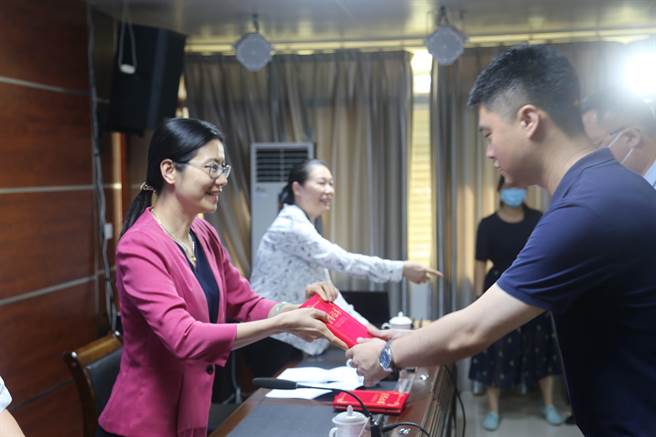 南寧市委常委、統戰部部長嚴麗萍為南寧市臺協會長周代祥頒發「優秀學員」證書。(圖文來源/廣西南寧市台辦，倫俊芝)