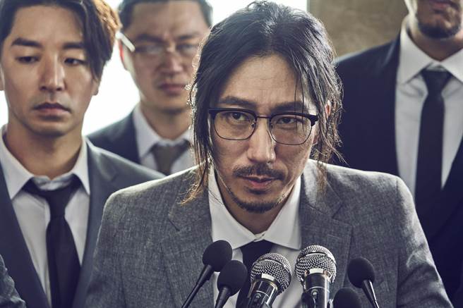 Tiger JK在〈虎心术Love Peace〉MV中扎着长髮穿着笔挺西装。（FEEL GHOOD MUSIC提供）