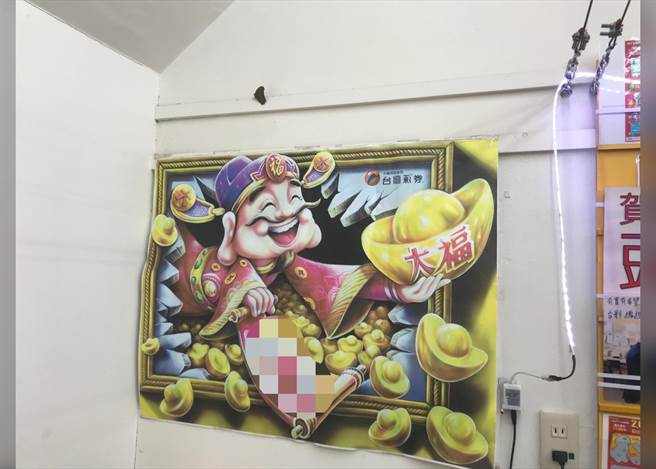 蝶蛾停栖在彩券行财神爷海报上，结果开出大乐透5.1亿头奖。（业者提供／陈淑娥台中传真）