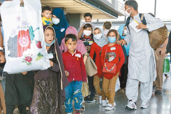 顺利从喀布尔机场撤离的阿富汗家庭26日抵达华府杜勒斯国际机场。（美联社）