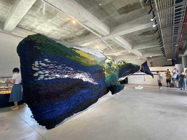 花莲县政府邀请艺术家陈圣文，在向日广场北边展区内，以山林、海边捡拾的各式各色废弃物，以刺绣及编织技法，创作一条长约十余公尺大鲸鱼形象，揭示被忽视的海废带来的伤害。（罗亦晽摄）