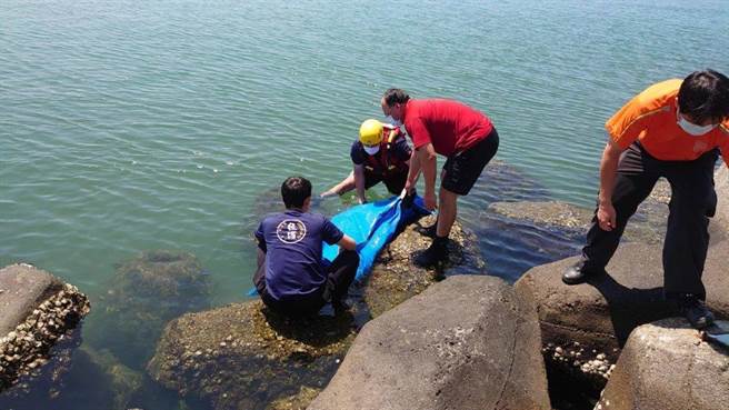 安平渔港29日发现浮尸卡消波块，海巡与警消携手搬运上岸。（海巡署提供）