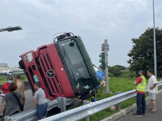 一辆满载稻谷的联结车今30日上午8点40分左右，要从嘉义交流道北上时，疑似未减速，加上车身重，竟在交流道入口环道侧翻。（国道警方提供∕吕妍庭嘉义传真）
