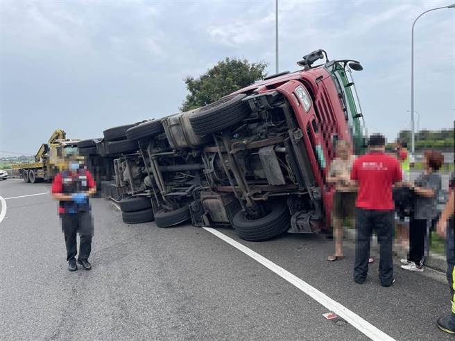 一辆满载稻谷的联结车今30日上午8点40分左右，要从嘉义交流道北上时，疑似未减速，加上车身重，竟在交流道入口环道侧翻。（国道警方提供∕吕妍庭嘉义传真）
