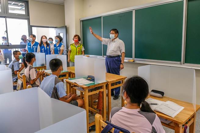 新竹县竹北市成功国中完成新校舍，县长杨文科（中）进新教室跟学生打招呼，每个桌位都有防疫隔板。（罗浚滨摄）