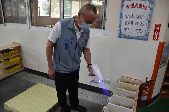 徐耀昌親自操作酒精槍清消幼兒園玩具。（謝明俊攝）