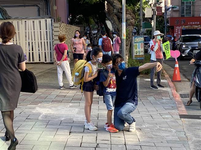 学生开心迎接上学日，和爸爸大玩自拍合影。（游念育摄）