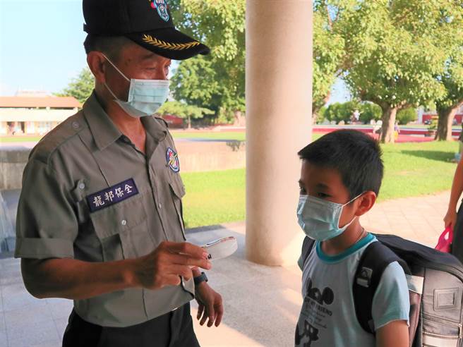 台南市后壁国小今天设置3条动线，由校方人员为学生量体温，并鼓励幼儿园和小一新生让孩子自己到教室报到。（张毓翎摄）