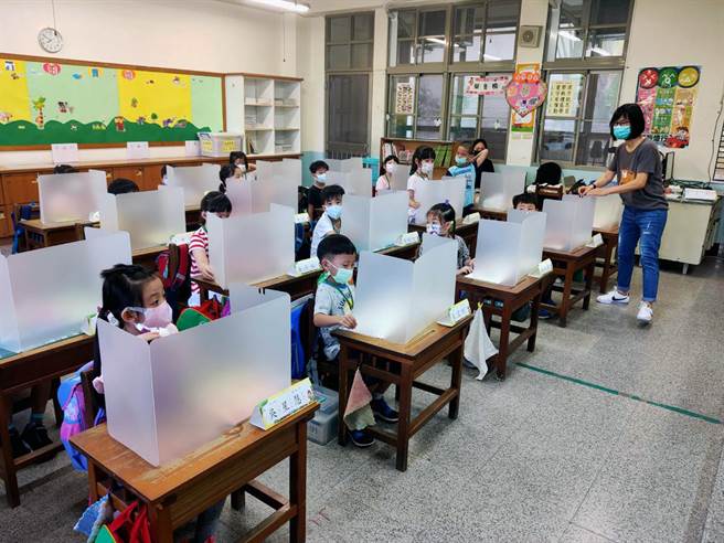台南市南区新兴国小一年级的班导师，教导新生如何正确使用隔板。（洪荣志摄）