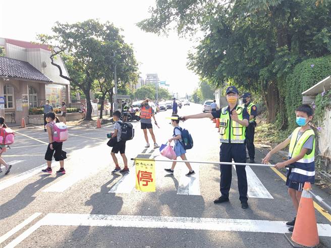 斗六分局員警在斗六市鎮南國小門口配合志工媽媽守護學童進入校門口。（斗六警方局提供）