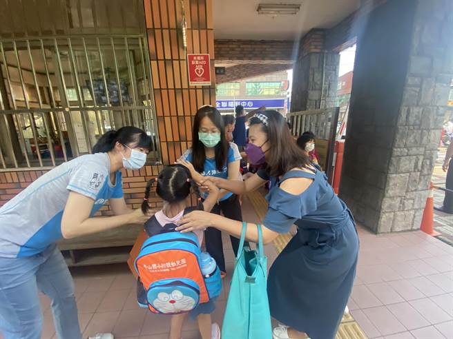 今天是疫情後的開學日，為了防疫家長無法入校，校門口盡是離情依依的畫面。（陳育賢攝）