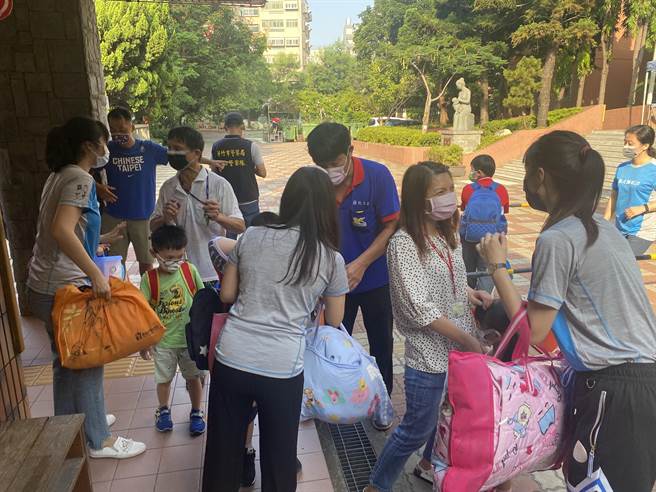 部分媽媽不放心，在校門口不斷提醒老師自己孩子該注意什麼。（陳育賢攝）