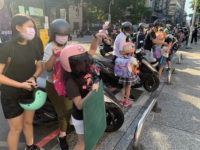 大批家长送小孩上学。（王扬杰摄）