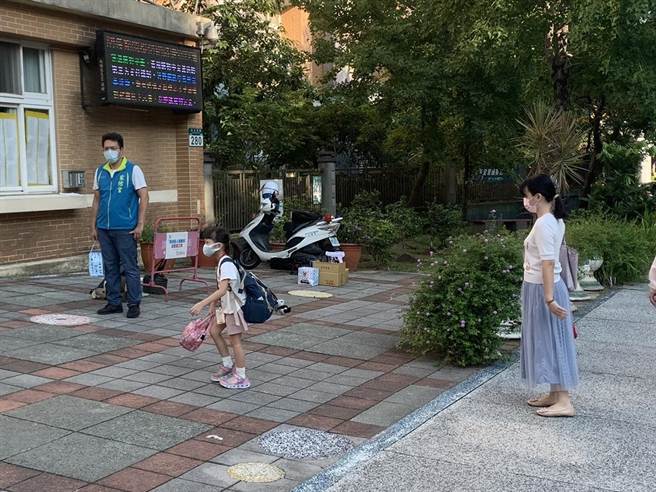 家长目送小孩进校门。（王扬杰摄）