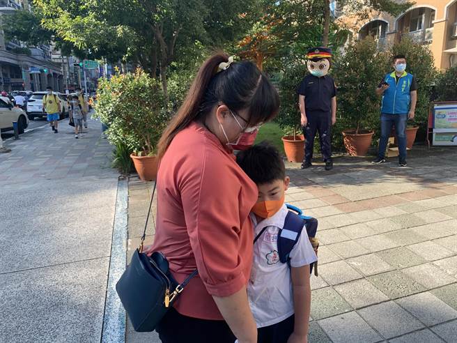 小一新生依偎妈妈怀抱，不舍得进校门。（王扬杰摄）