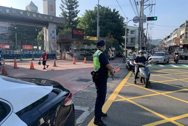 开学了，中市警局雾峰分局启动护童勤务，员警即时指挥送小孩到校的临停车辆，尽快驶离，以维持校园周边交通秩序。（雾峰分局／黄国峰台中传真）