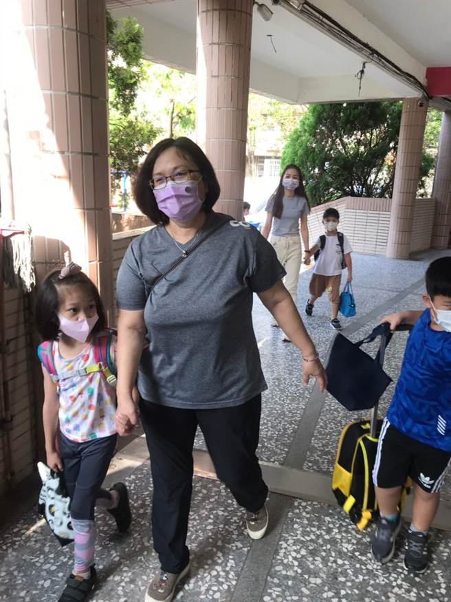 鎮南國小老師親自在校門口迎接小一小朋友，牽手走入教室。（周麗蘭攝）