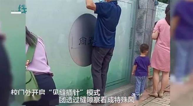 新生開學，家長一字排開隔牆暗中觀察成為奇景。（截自影片）