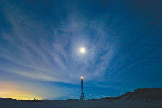 摄影师黄一盛拍下国圣港灯塔的亮光与月光相映成趣的景色。（黄一盛提供／张毓翎台南传真）