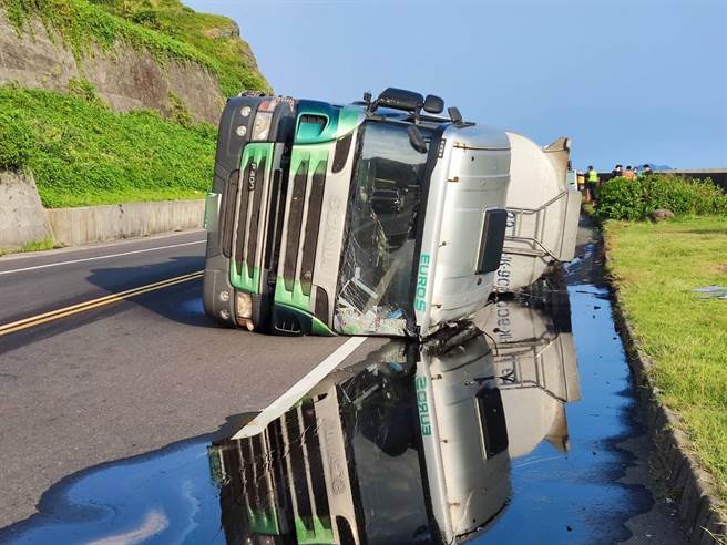 新北市瑞芳区台2线79.5K处2日清晨1辆载运硫酸的大型化学槽车疑似在过弯时转弯不慎导致整台车翻覆，车载运的硫酸也当场不断渗漏。（民眾提供）