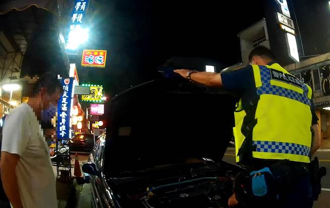 民眾发现一只猫咪受困路旁汽车引擎室内，雾峰分局国光派出所员警，找来车主开门，车主一紧张竟也忘记引擎盖怎么开。（雾峰分局／黄国峰台中传真）