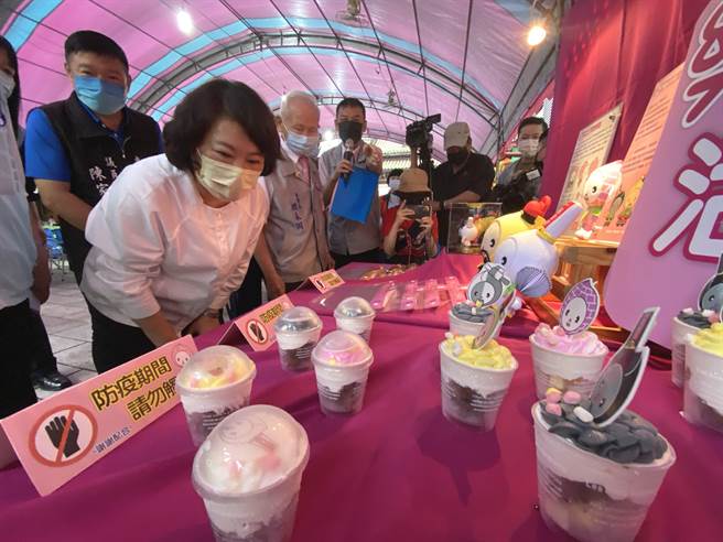 嘉义市长黄敏惠仔细观看嘉义城隍庙「乐桃城隍」系列文创品。（廖素慧摄）