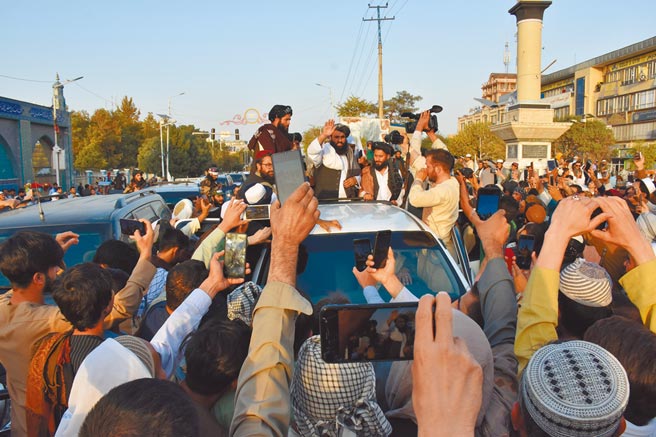 在阿富汗北部巴爾赫省首府馬扎里沙里夫，塔利班人員8月31日出現在當地街頭時，被民眾圍繞。塔利班組織日前召開領導人會議，討論組建政府等事宜。（新華社）
