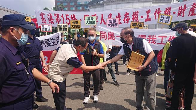 台南市育乐事业商业权益促进会理事长曾正义（右）向台南市副秘书长王扬智（左）递交陈情书。（程炳璋摄）