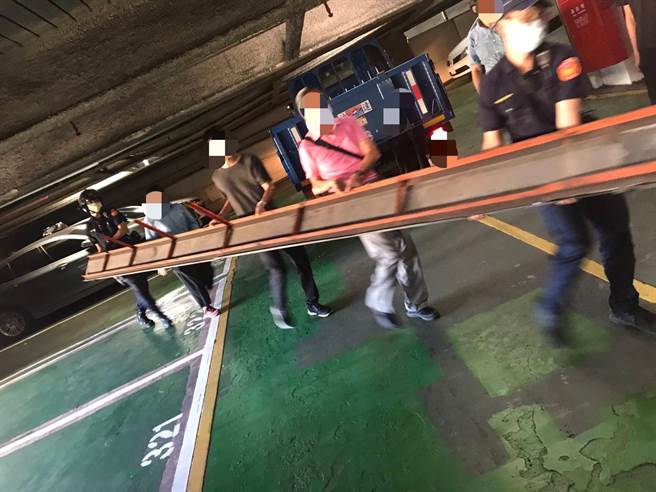 警员与在旁之数位民眾，合力将钢梁搬离后恢復停车场内之通行顺畅。(警方提供)