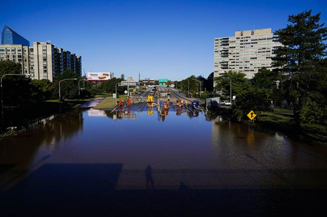 在倾盆大雨过后，工人们正在为费城676号州际公路被淹没的路段上抽水。（美联社）