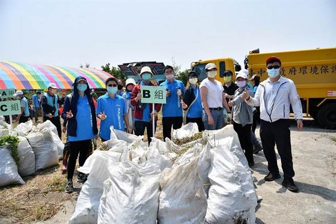 拔蔓志工将拔除的小花蔓泽兰装袋。（东势林管处提供／王文吉台中传真）