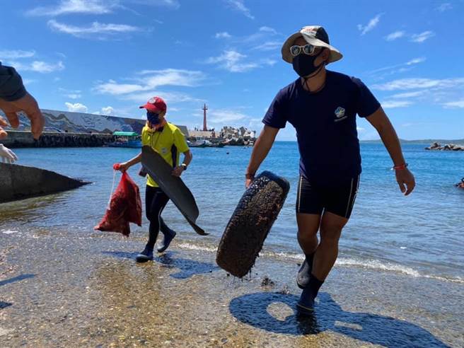 台东水中运动训练协会在台东县东河乡新兰渔港净海、净滩，协会成员严先生（右）呼吁钓客将垃圾随手带走。（蔡旻妤摄）