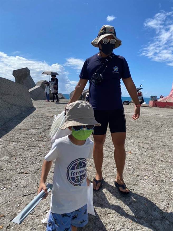 台东水中运动训练协会在台东县东河乡新兰渔港净海、净滩，协会成员严先生（右）呼吁钓客将垃圾随手带走。（蔡旻妤摄）