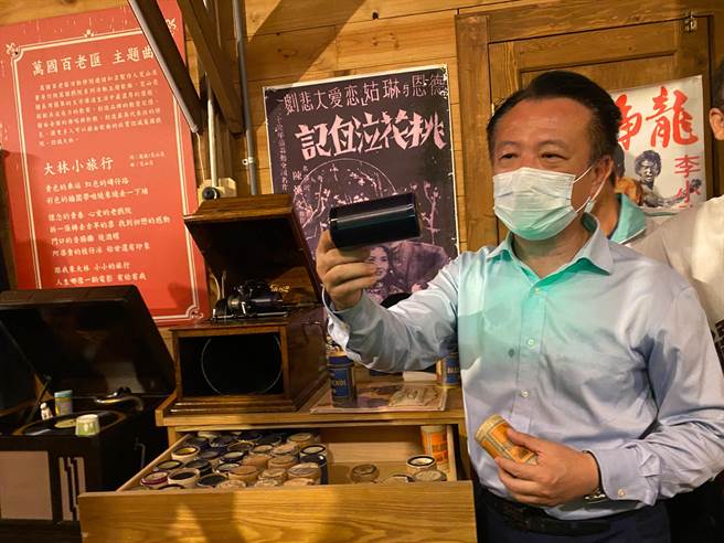 嘉义县长翁章梁听江明赫尝试使用爱迪生发明的蜡筒留声机。（张亦惠摄）