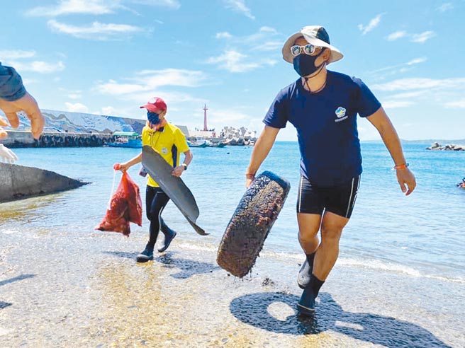 台东水中运动训练协会在台东县东河乡新兰渔港净海、净滩，协会成员严先生（右）呼吁钓客将垃圾随手带走。（蔡旻妤摄）