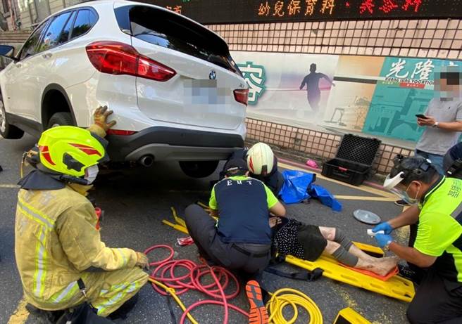 救护人员使用破坏器材将妇人从车底救出。（翻摄照片／陈彩玲基隆传真）