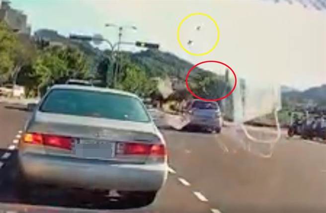 台中惊悚车祸，骑士（红圈处）遭撞后喷飞空中宛如「风火轮」旋转，而机车零件也喷飞空中（黄圈处）。（截自《爆怨公社》影片）