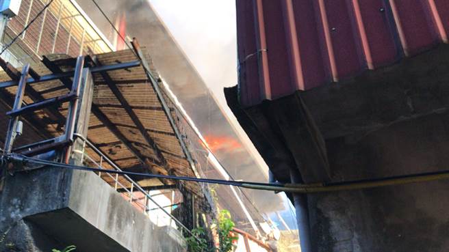 基隆市七堵區工建路7日下午4點多驚傳火警，住宅3樓頂樓加蓋鐵皮屋不斷竄出火勢。（陳彩玲攝）