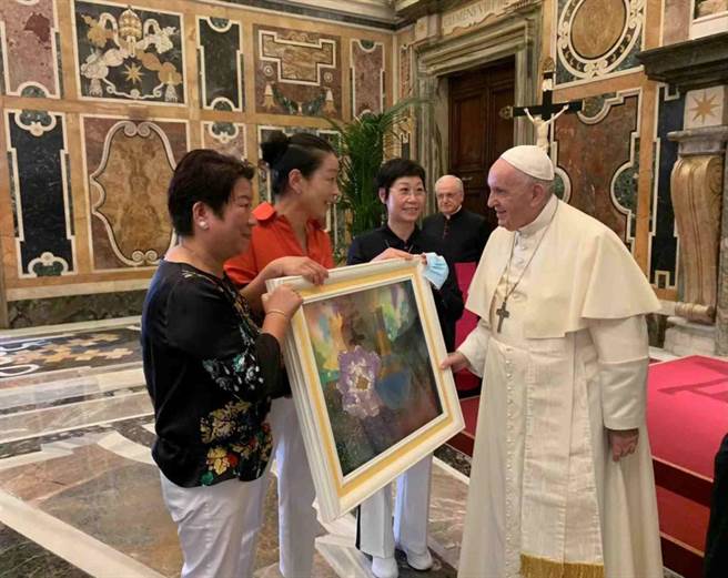 梵蒂岡教宗方濟各（右）欣喜親自接收台灣藝術家白魚的作品，經由義大利Arche基金會代表，致上來自台灣藝術家白魚的畫作「富貴平安」。（擷取自梵蒂岡官網／柯宗緯高雄傳真）